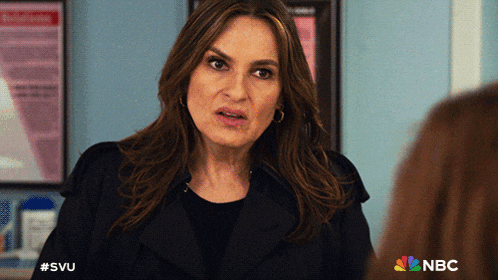 a woman in a black coat stands in front of a sign that says #svu
