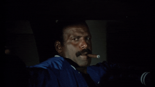 a man wearing a blue jacket is smoking a cigar