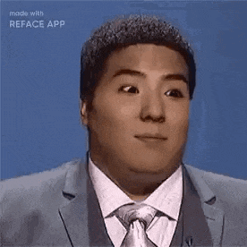 a man in a suit and tie is making a surprised face .