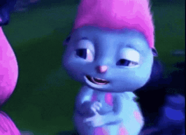 a blue cartoon character with a pink hat on is smiling