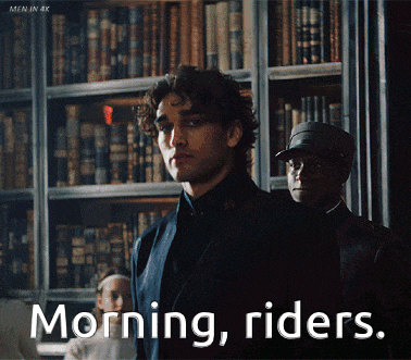 a man in a suit stands in front of a bookshelf with the words morning riders above him