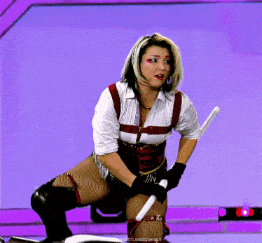 a woman is kneeling down holding a sword and the words wrestlingsquibble are on the bottom right