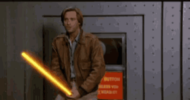 a man is holding a light saber in front of a button that says button