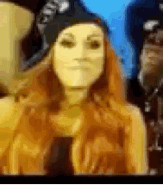 a woman with red hair is wearing a hat and smiling in a blurry picture .