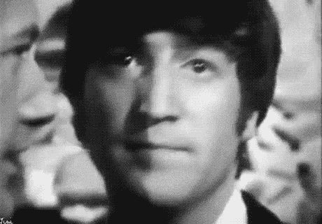 a close up of a man 's face in a black and white photo with a crowd in the background .