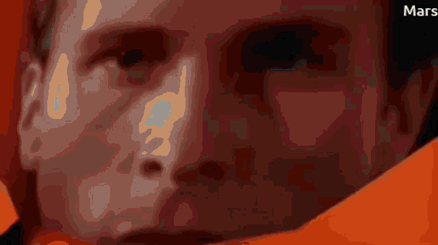 a close up of a man 's face with the word mars on the bottom right