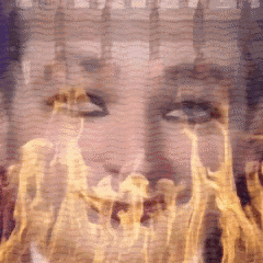 a close up of a person 's face with flames coming out of it