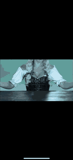 a woman is sitting at a table with her arms outstretched in front of a stock photo