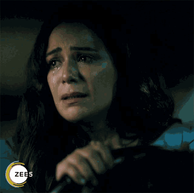 a woman with a tear coming out of her eye and a zees logo in the corner