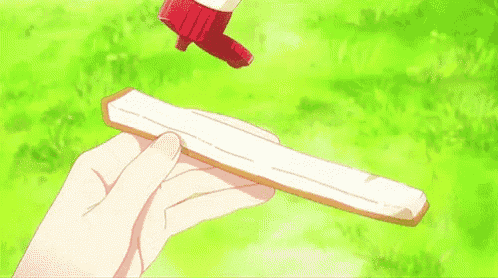 a person is holding a piece of bread with a bottle of ketchup being poured on it .