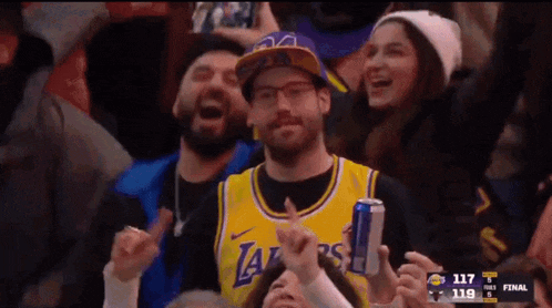 a man in a lakers jersey is holding a can