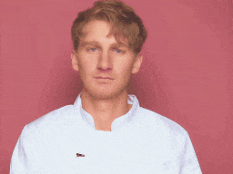 a man wearing a white shirt with a bee pin on his chest