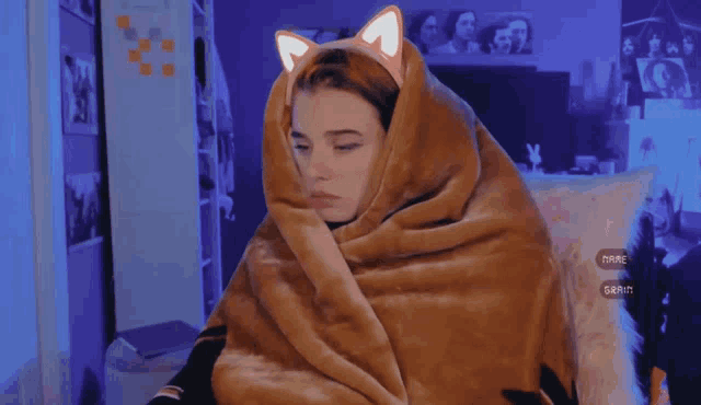 a woman wrapped in a blanket with a cat ear on her head