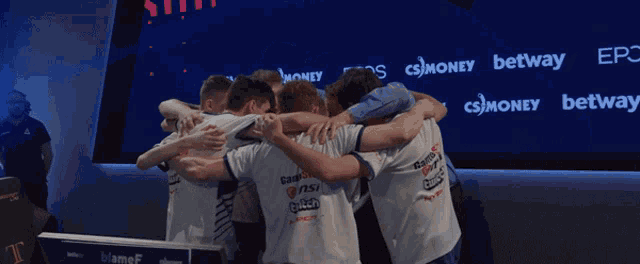 a group of people hugging each other in front of a wall that says ' betway ' on it