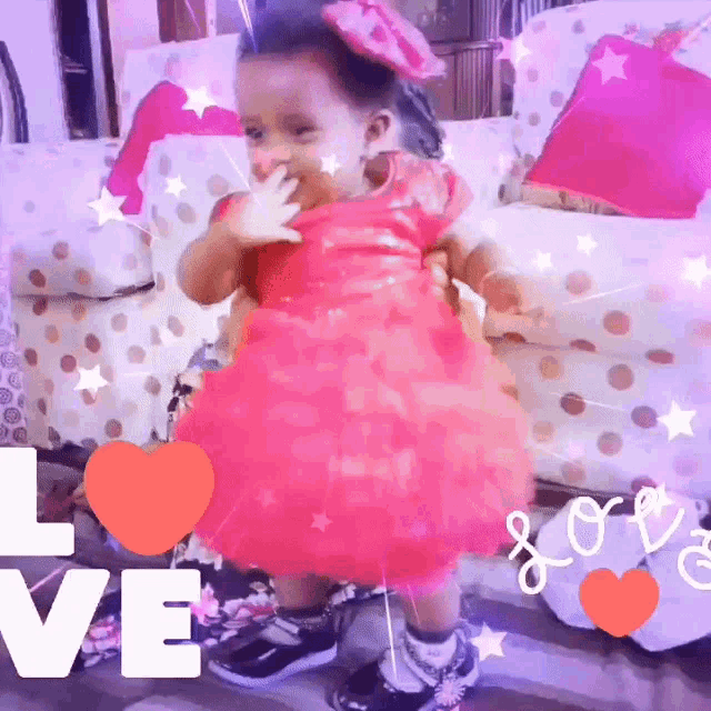 a little girl in a red dress is standing in front of a chair with the word love on it