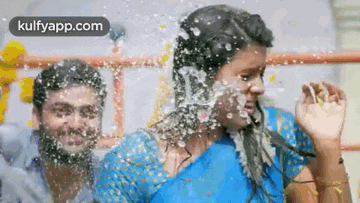 a man and a woman are standing next to each other in the water .