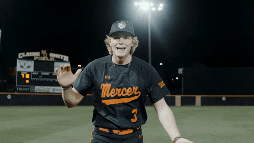 a baseball player wearing a mercer jersey stands on the field