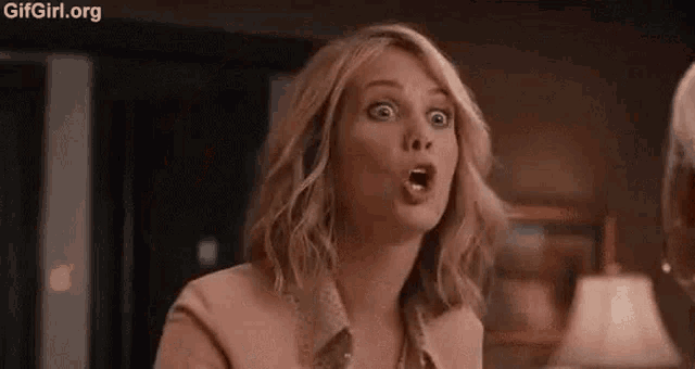 a woman is making a funny face while talking to a man in a living room .