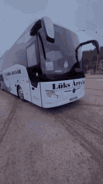 a luxs artvin bus is parked in a dirt lot