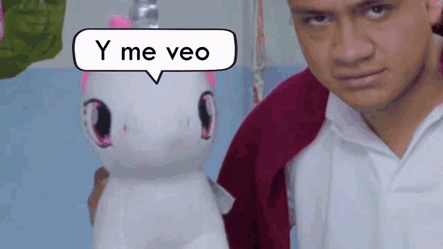 a man is holding a stuffed unicorn with a speech bubble that says y me veo