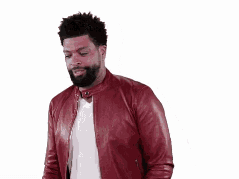 a man in a red leather jacket is making a scary face .