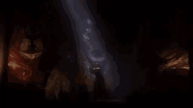 a dark room with a light shining through the ceiling