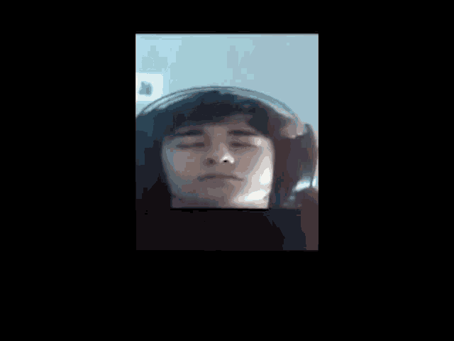 a close up of a person 's face with their eyes closed and a black background .
