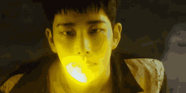 a close up of a man 's face with a yellow light shining on it