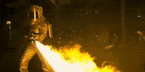 a man in a protective suit is holding a fire hose