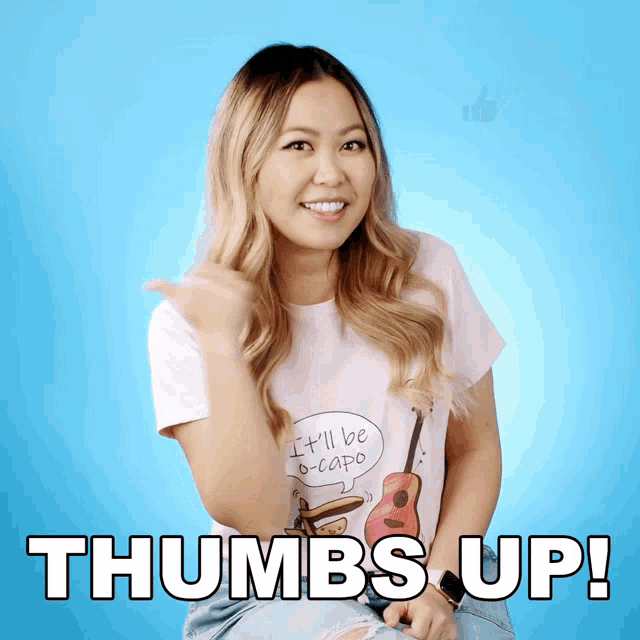 a woman wearing a shirt that says it 'll be b-capo is giving a thumbs up
