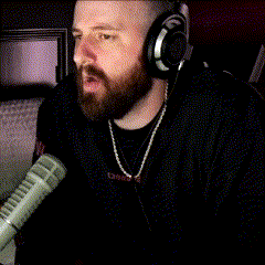 a man with a beard wearing headphones and a necklace with the word camp on it