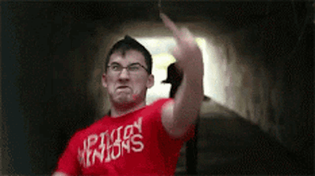 a man wearing a red shirt that says shipwreck nation on it