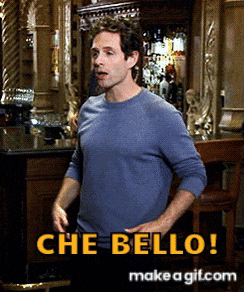 a man in a blue shirt is standing in front of a bar with the words che bello written in yellow