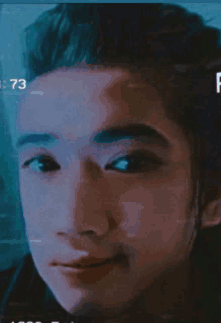 a close up of a man 's face with the number 73 visible
