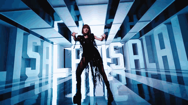a woman in a black dress is dancing in a room with the word lisa in white letters