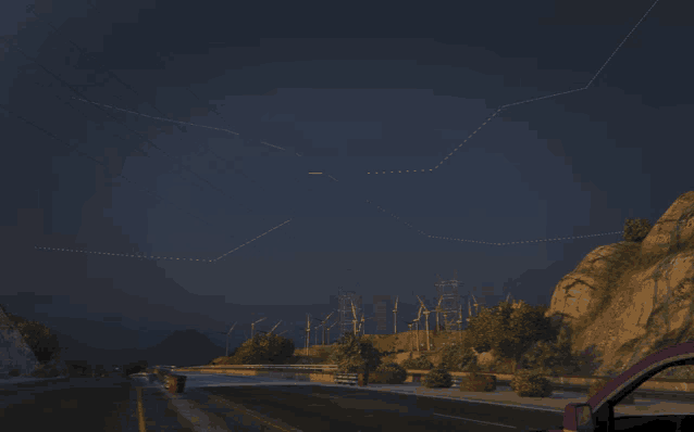 a car is driving down a road at night with mountains in the background