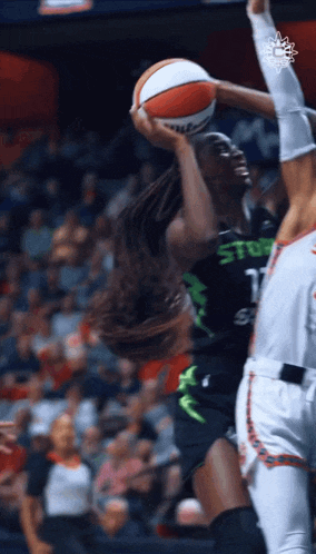 a female basketball player wearing a black and green uniform with the number 1 on it