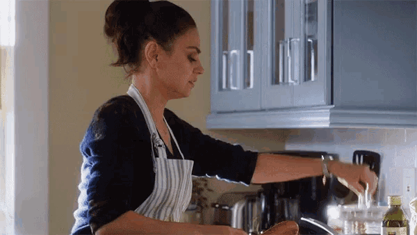 a woman in an apron is preparing food in a kitchen