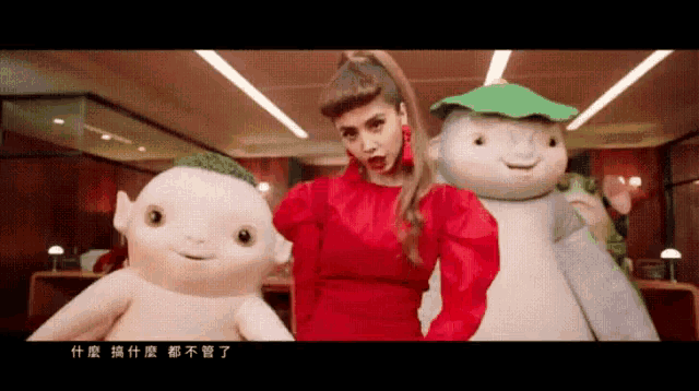 a woman in a red dress stands between two stuffed animals