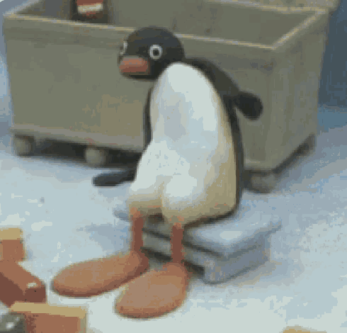 a stuffed penguin is sitting on a stool with its legs crossed