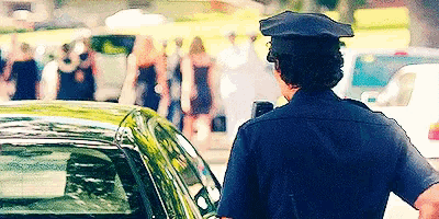 a police officer is standing in front of a car with a sign that says no parking