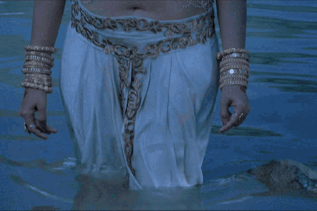 a woman wearing a nose ring is standing in a body of water