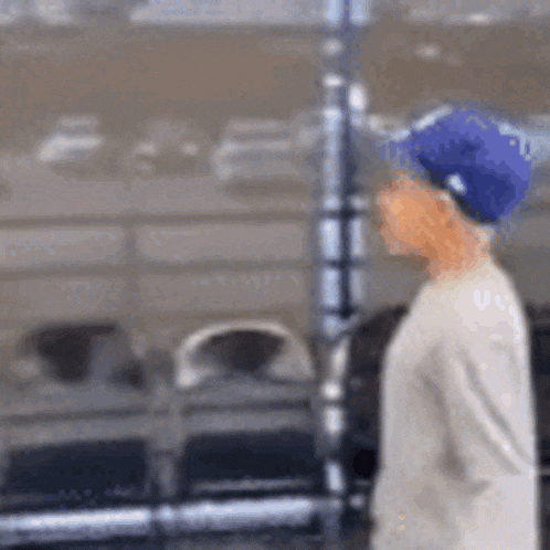 a blurry picture of a person wearing a blue hat and a white shirt