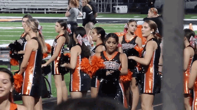 a group of cheerleaders wearing black and orange uniforms with the word falcon on the front