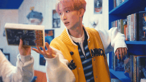 a boy with pink hair wearing a yellow jacket that says imo