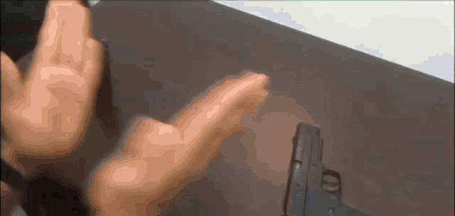 a person is holding a gun in front of a table
