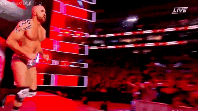 a wrestler is walking out of a ring during a live broadcast .