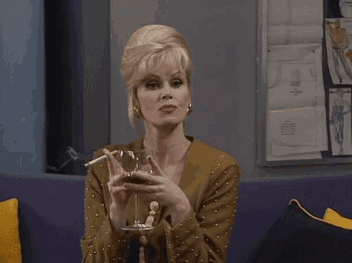 a woman is smoking a cigarette and drinking a glass of wine