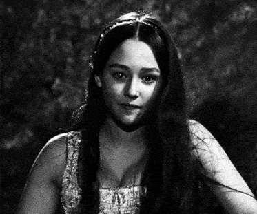 a black and white photo of a woman with long hair and a tiara on her head