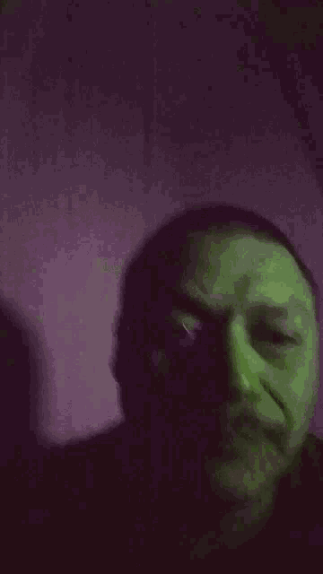 a man with a mustache has a green background